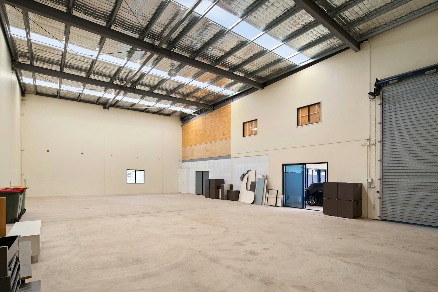 Empty industrial warehouse with polished concrete floors and high ceilings.