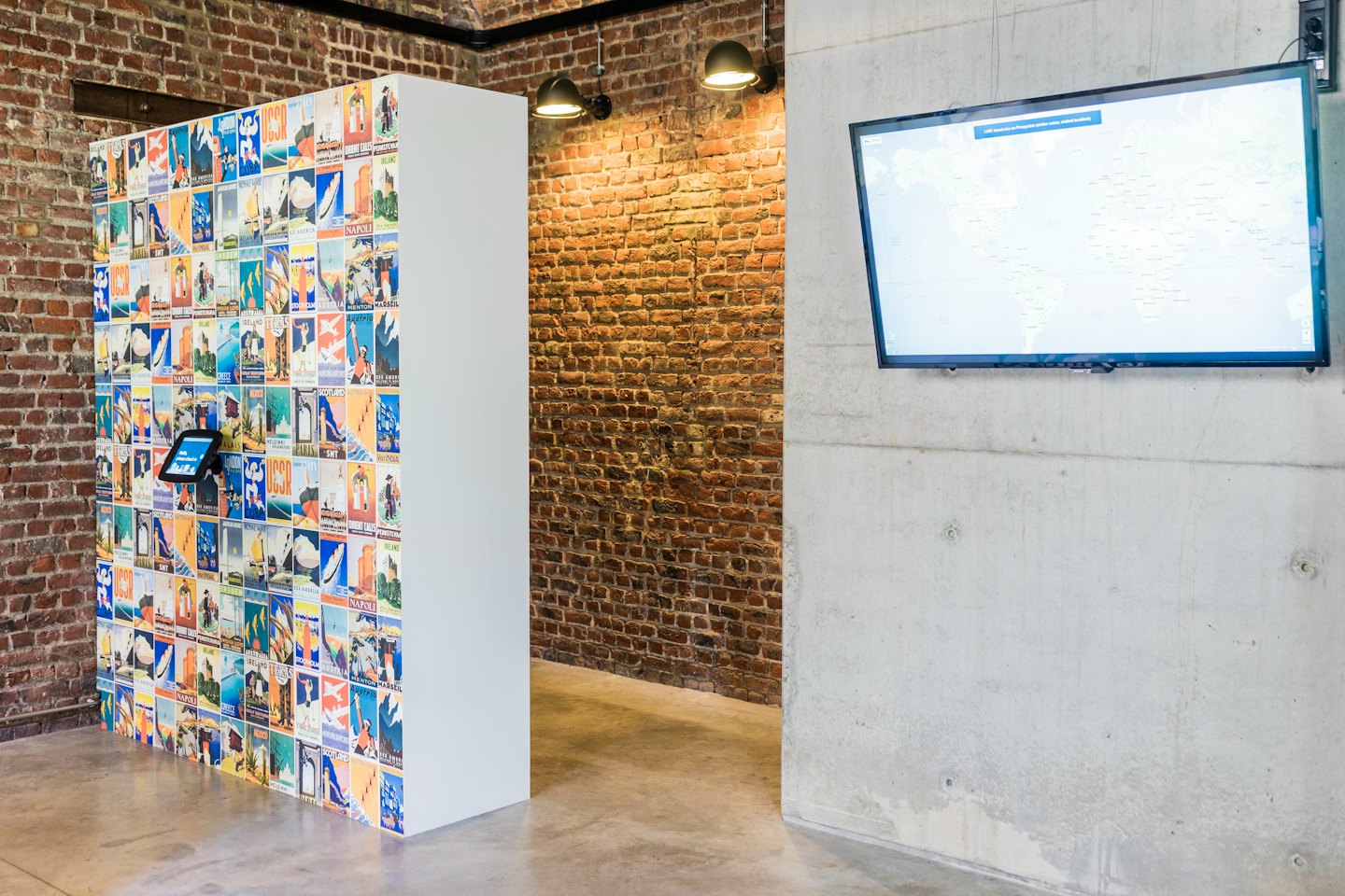 Modern office space with vintage travel posters and world map display.