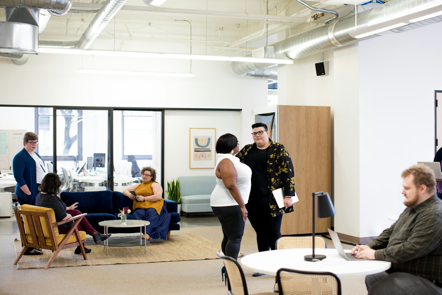 Diverse professionals collaborating in a modern open-plan office lounge.